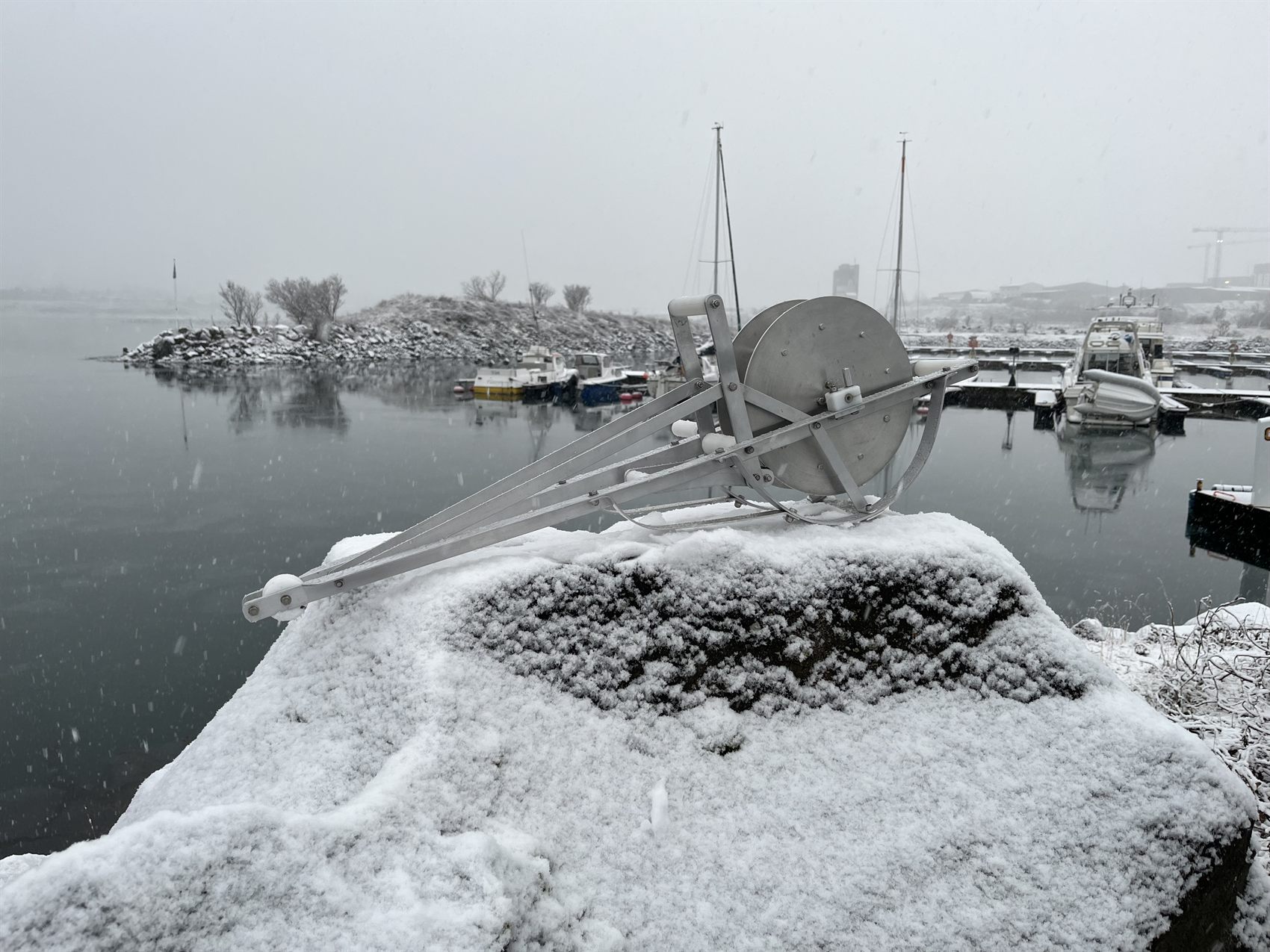 Atlantic Reels manual reel beside a small harbor in winter conditions